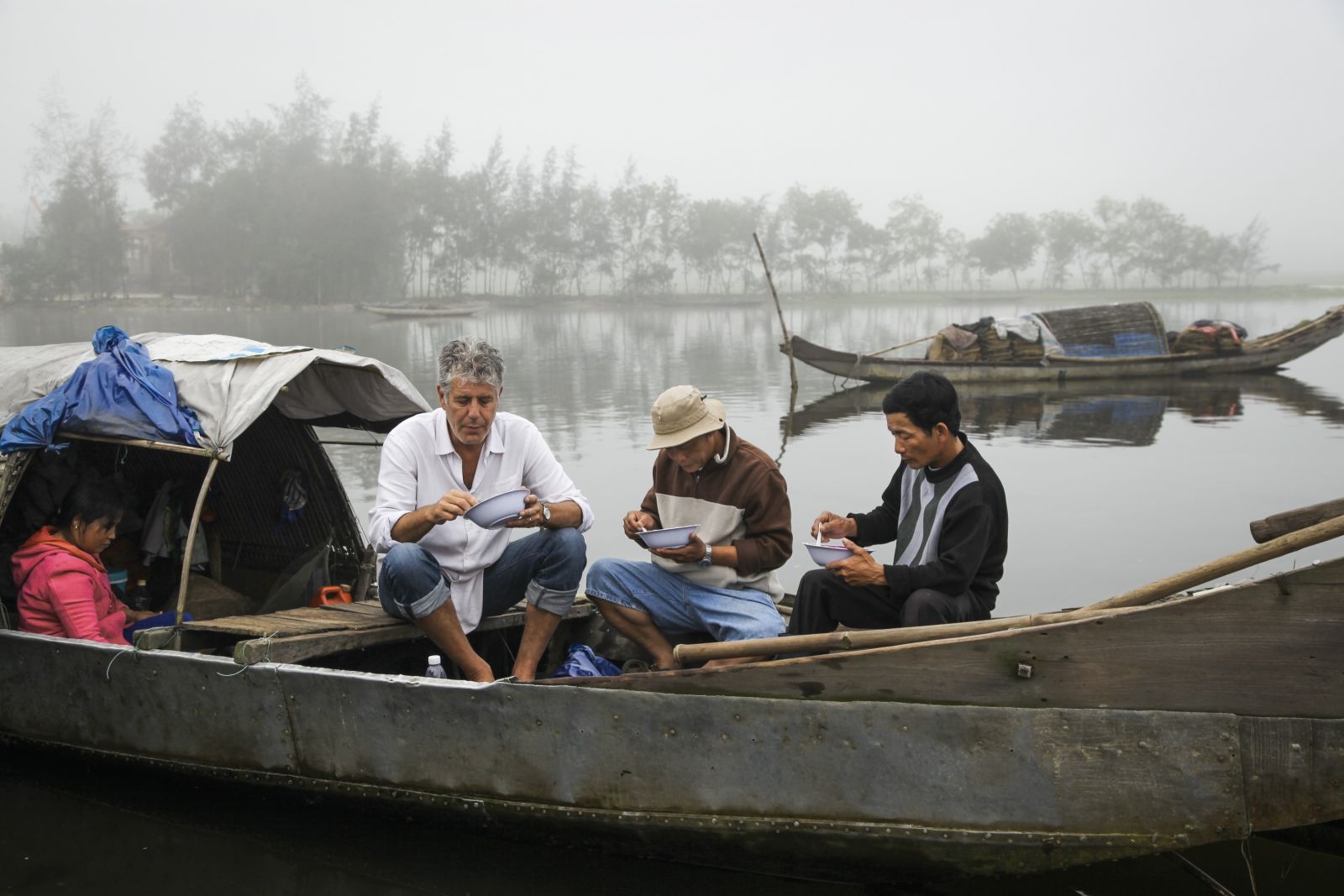 Bourdain enjoys a bite of food while on location in Vietnam
